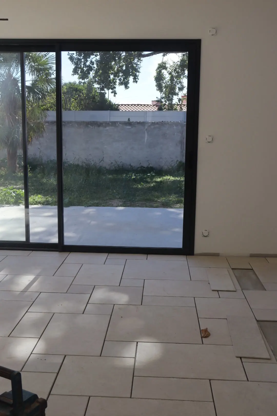 Séjour carrelé en opus ouvert sur un jardin